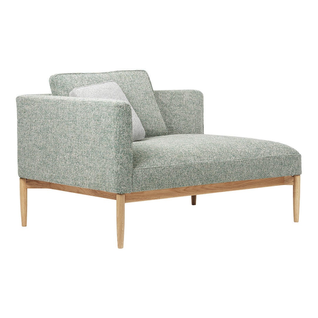 Green patterned armchair with light wood legs and a soft gray accent pillow. Modern design for stylish living spaces.