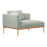 Green patterned armchair with light wood legs and a soft gray accent pillow. Modern design for stylish living spaces.