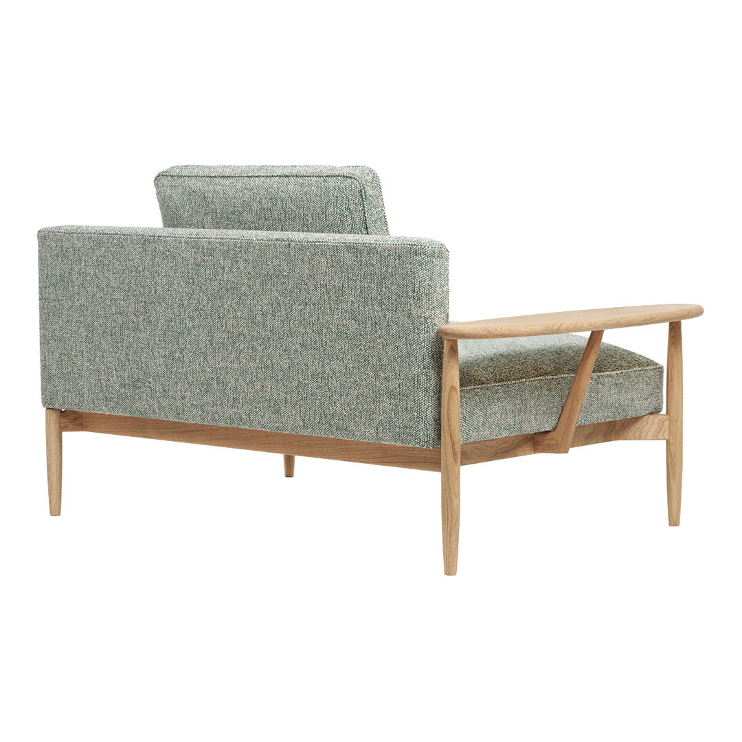 Green patterned upholstery on a mid-century modern sofa with wooden frame and legs.