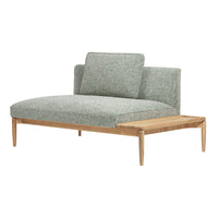 Textured green upholstery on a sleek, modern sofa with natural wood accents and minimalist design.