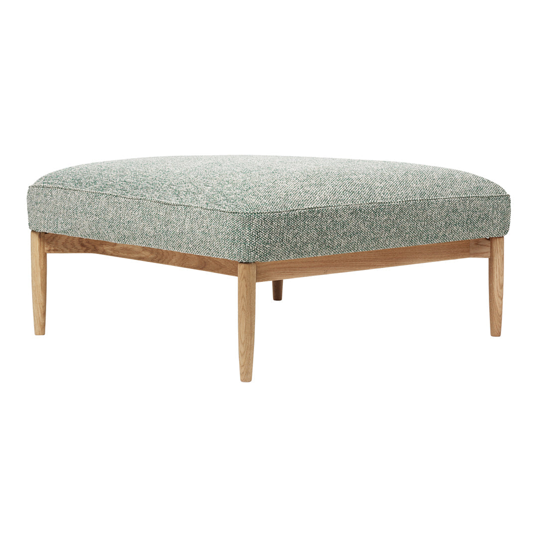 Green patterned ottoman with light wood legs, featuring a textured fabric design. Perfect for modern decor.