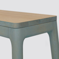 Light wood tabletop with a soft blue finish, featuring clean lines and a minimalist design. Perfect for modern decor.