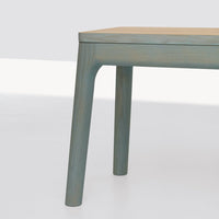 Light blue wooden table leg with subtle grain, minimalist design, and smooth finish against a neutral background.