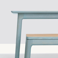 Light blue table with natural wood accents, featuring smooth lines and a minimalist design. Perfect for modern decor.