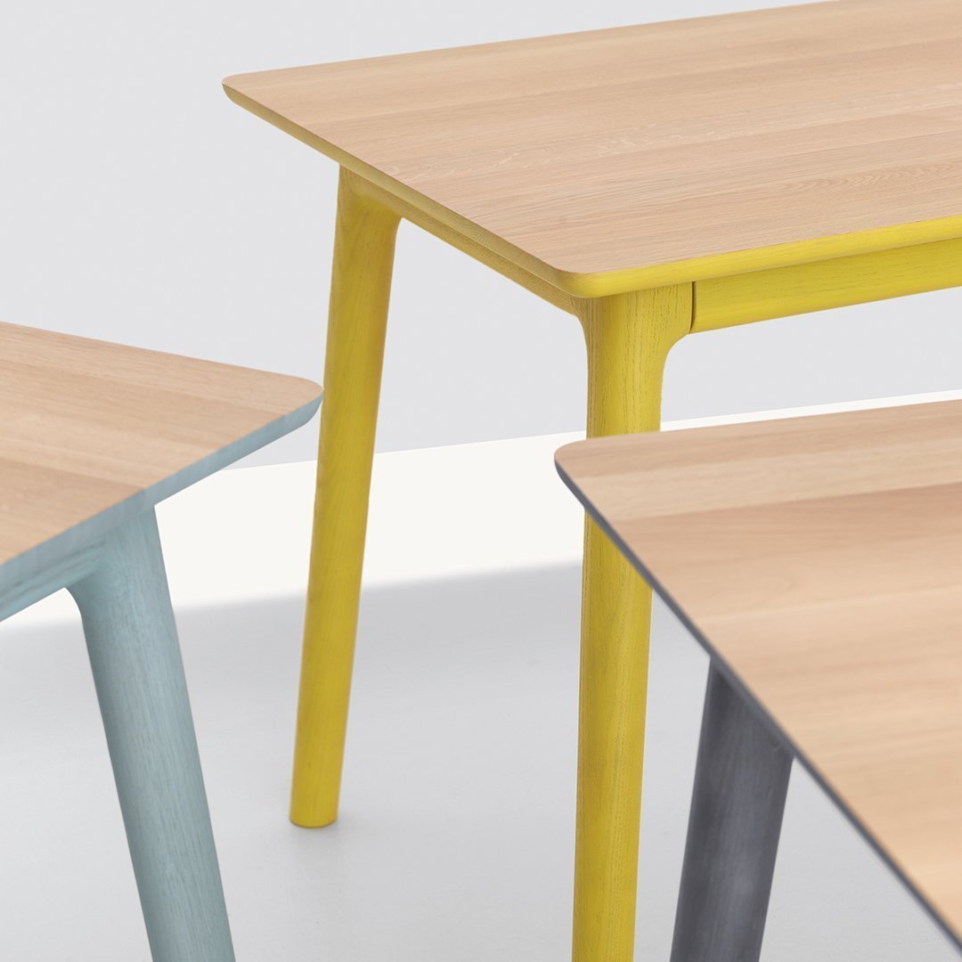 Light wood tables with pastel blue, yellow, and gray legs in a modern design. Perfect for contemporary living spaces.