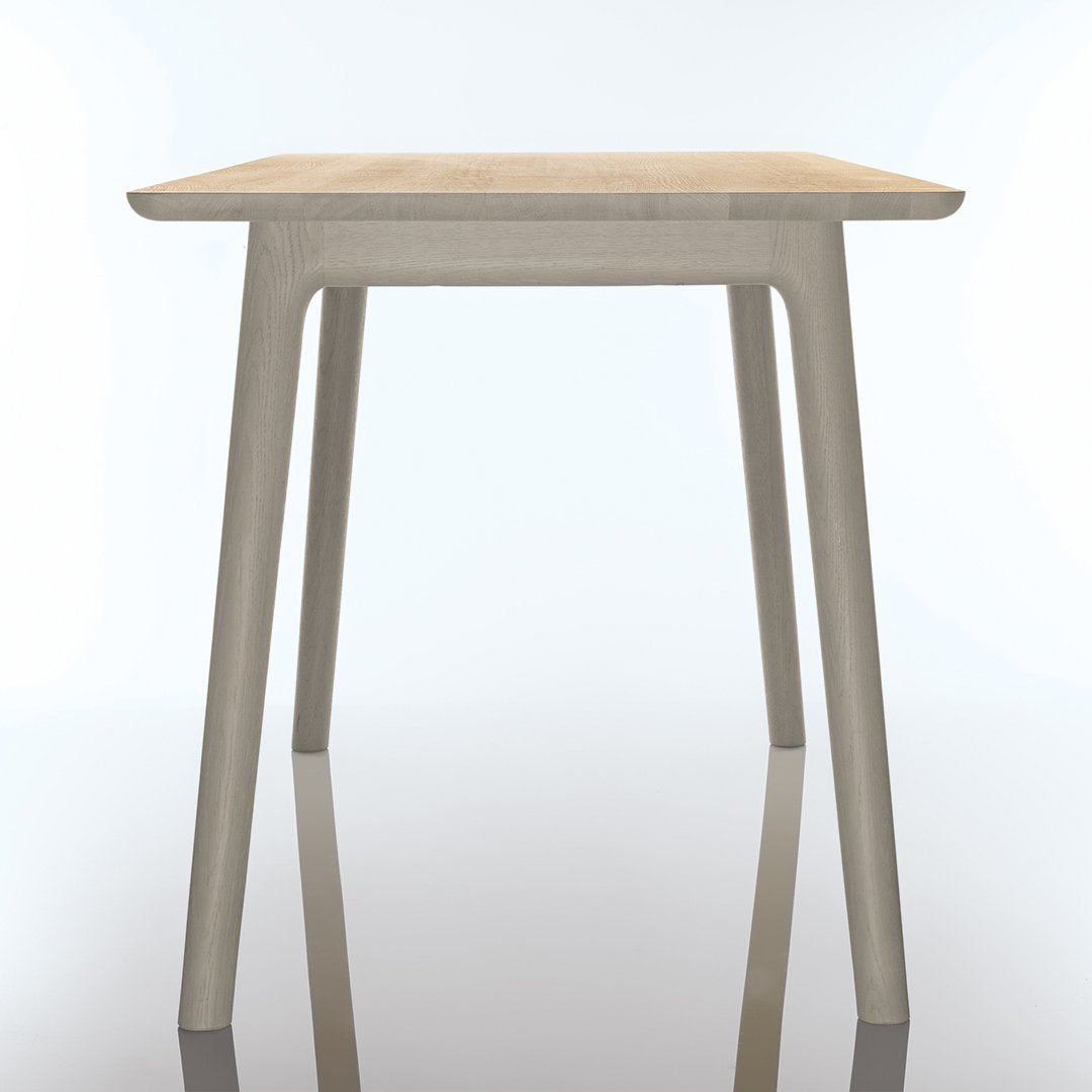 Light wood tabletop with a smooth finish, paired with sleek, neutral-colored legs for a modern look.