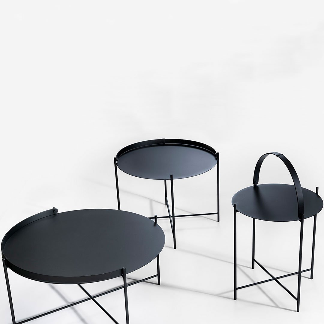 Black roundtables with sleek, matte finishes and minimalist designs, featuring varying heights and unique silhouettes.