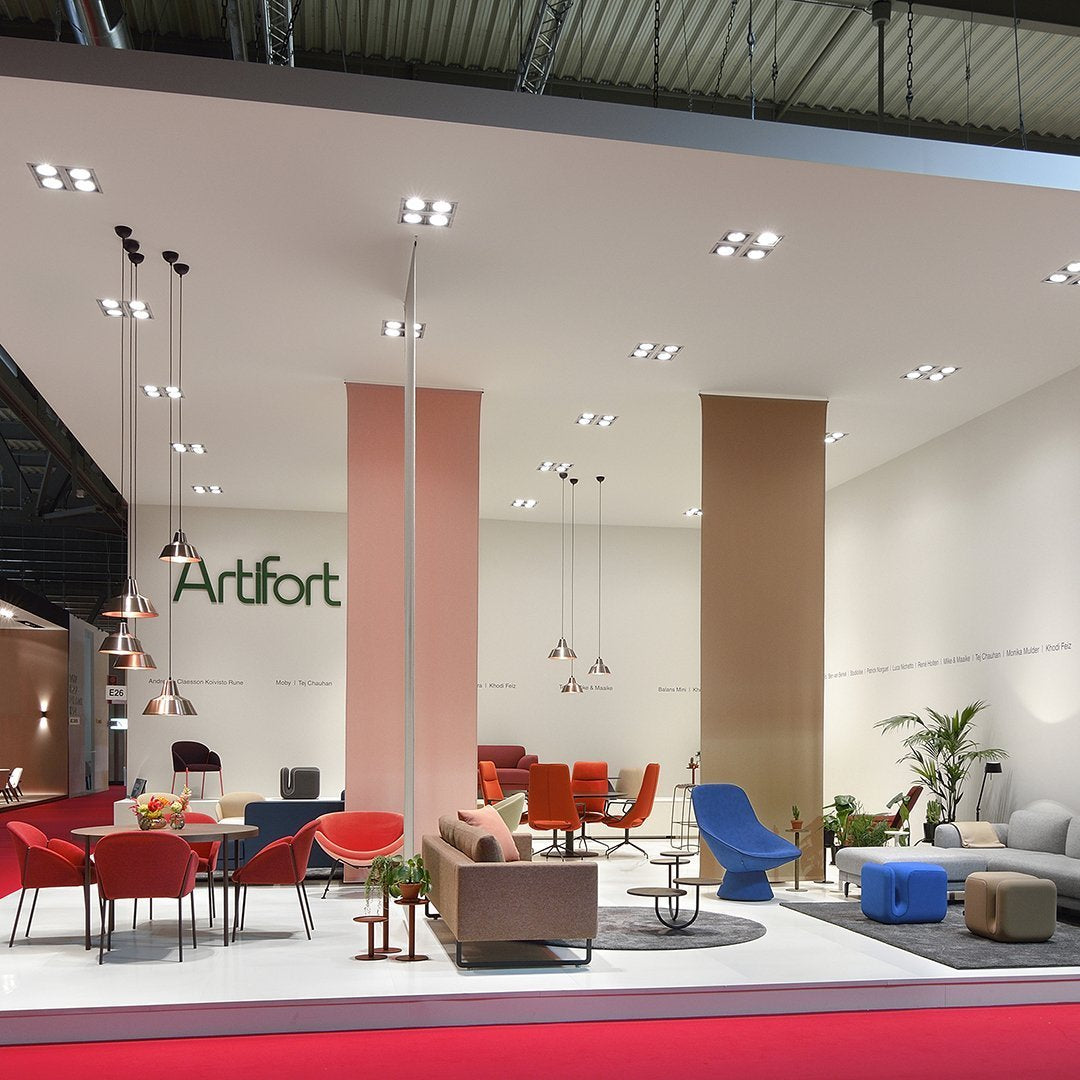 Modern furniture display featuring vibrant reds, blues, and neutral tones with geometric patterns and stylish accents.
