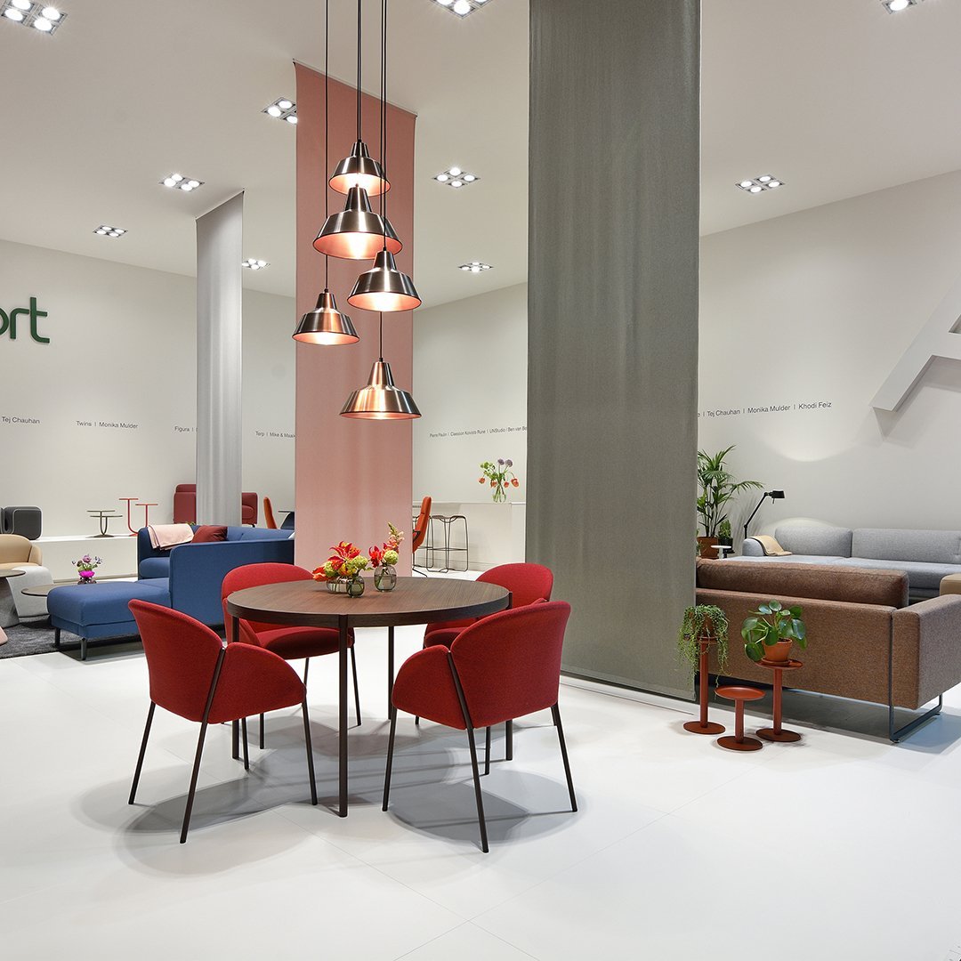"Modern interior with red chairs, sleek gray panels, and soft pastel accents creating an inviting atmosphere."