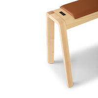 Light natural wood bench with a rich brown leather cushion, featuring clean lines and a minimalist design.