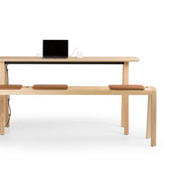 Light wood furniture with a smooth finish, accented by brown leather cushions, featuring a minimalist design.