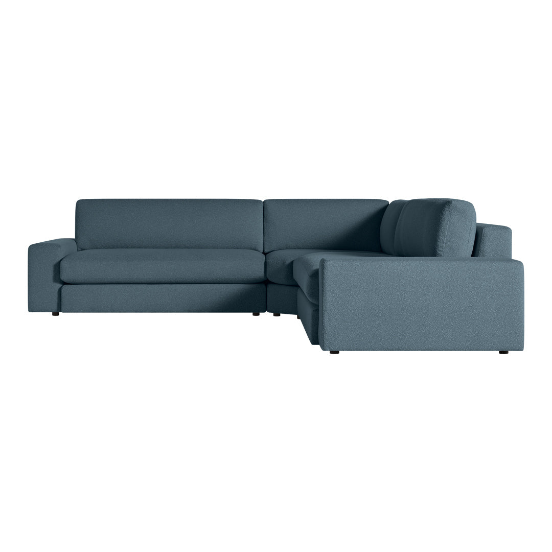 Blue sectional sofa with a modern design and smooth fabric texture. Perfect for contemporary living spaces.