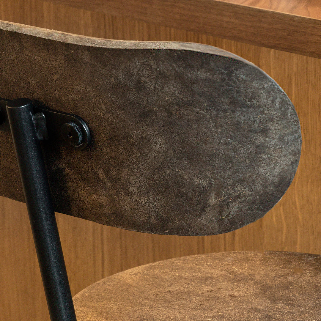 Vintage brown leather chair with a smooth texture, featuring a rich, muted color and sleek black metal accents.