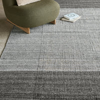 Gray area rug with subtle textured patterns, featuring gradients from light to dark tones. Stylish and modern design.