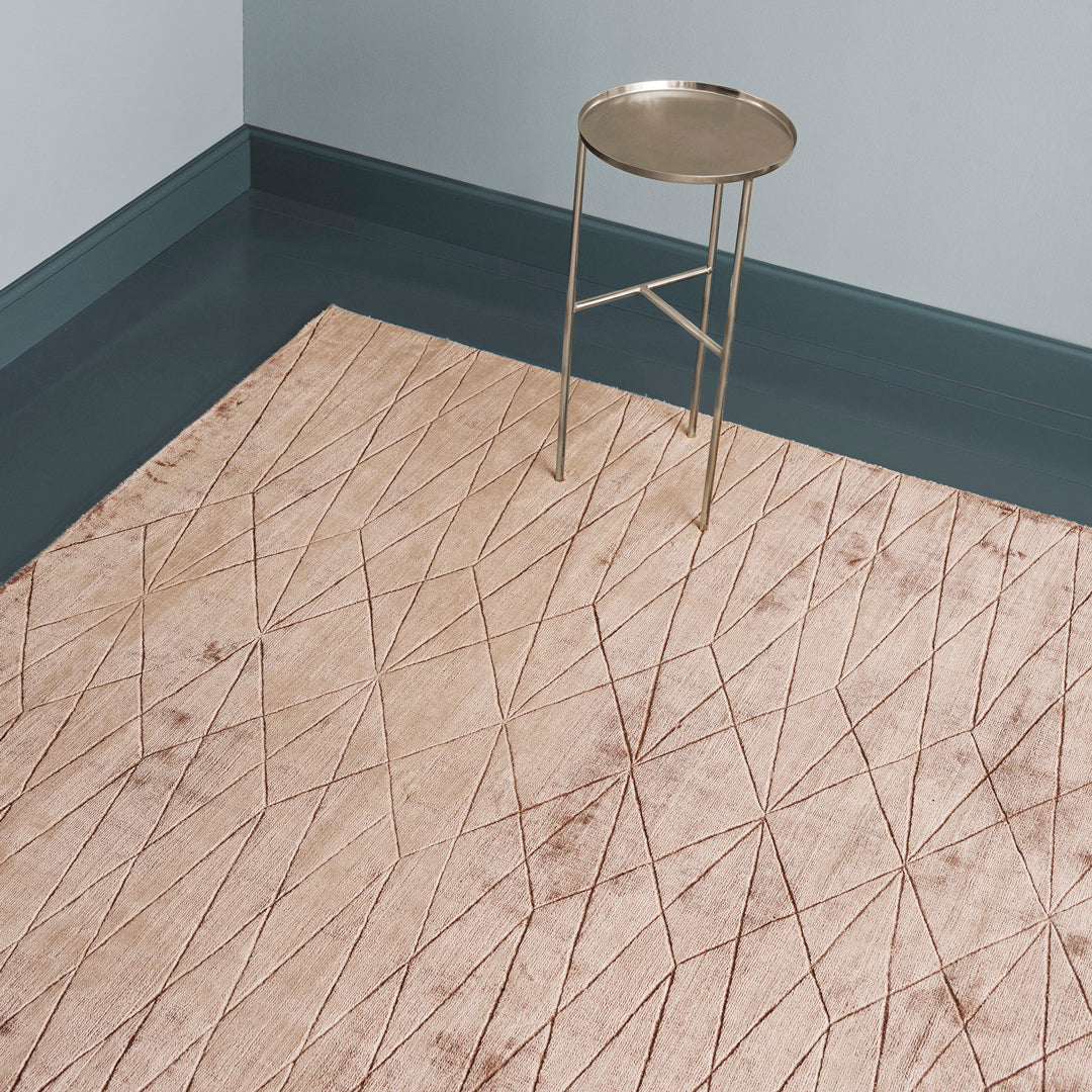 Beige area rug with geometric diamond pattern and gold accents, creating a modern and stylish interior look.