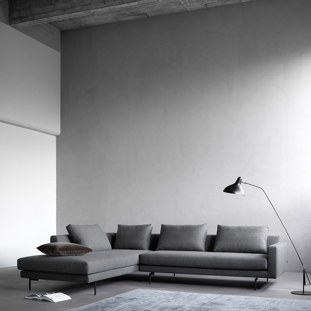 Modern gray sectional sofa with a sleek design and subtle texture, complemented by a minimalist aesthetic.