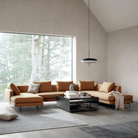 Brown sectional sofa with sleek lines, paired with a dark coffee table and gray area rug in a modern living space.