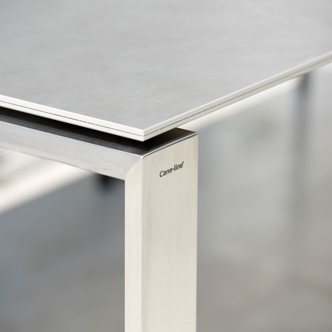 Sleek gray tabletop with silver metal legs, featuring a modern, minimalist design. Perfect for contemporary spaces.