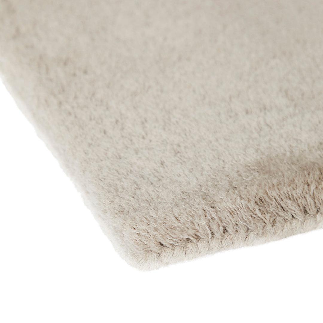 Soft beige rug with a subtle texture and no patterns, perfect for a minimalist decor.
