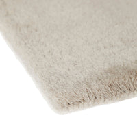 Soft beige rug with a subtle texture and no patterns, perfect for a minimalist decor.