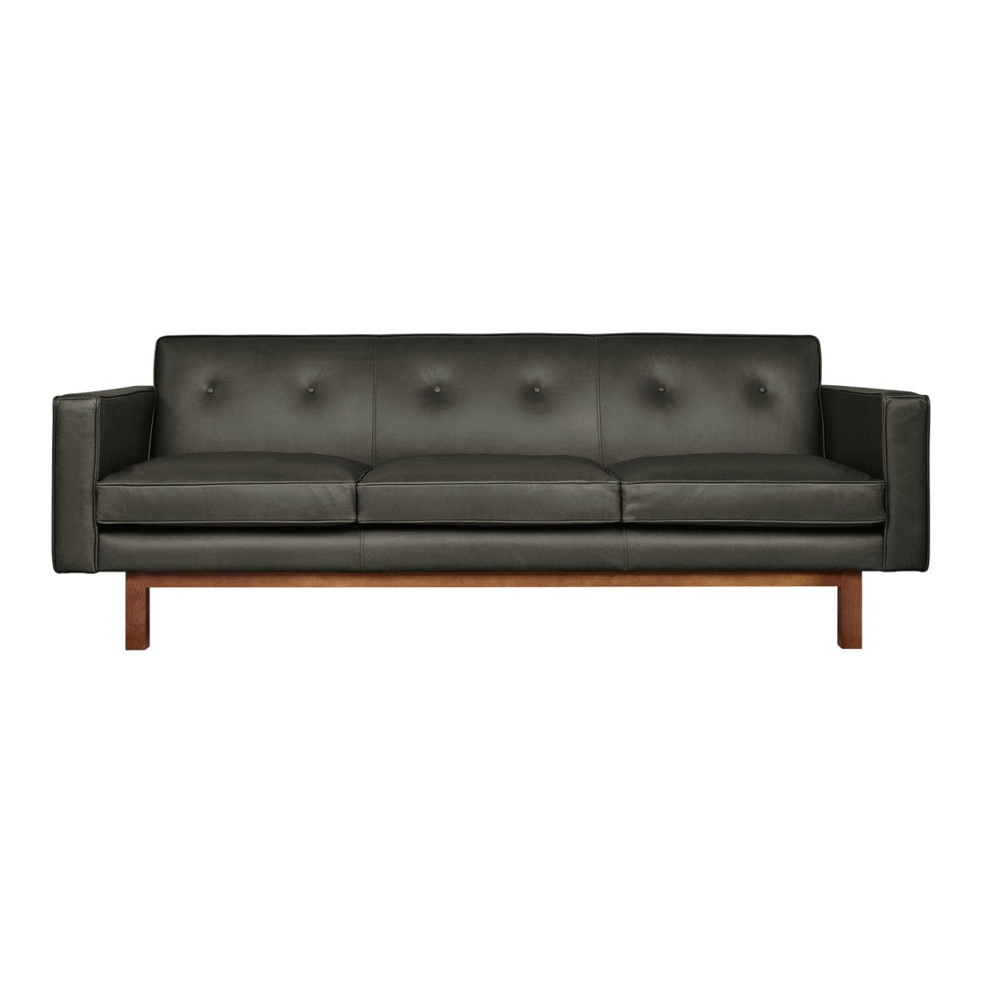 Dark gray leather sofa with tufted design and wooden legs, offering a modern and sleek aesthetic.