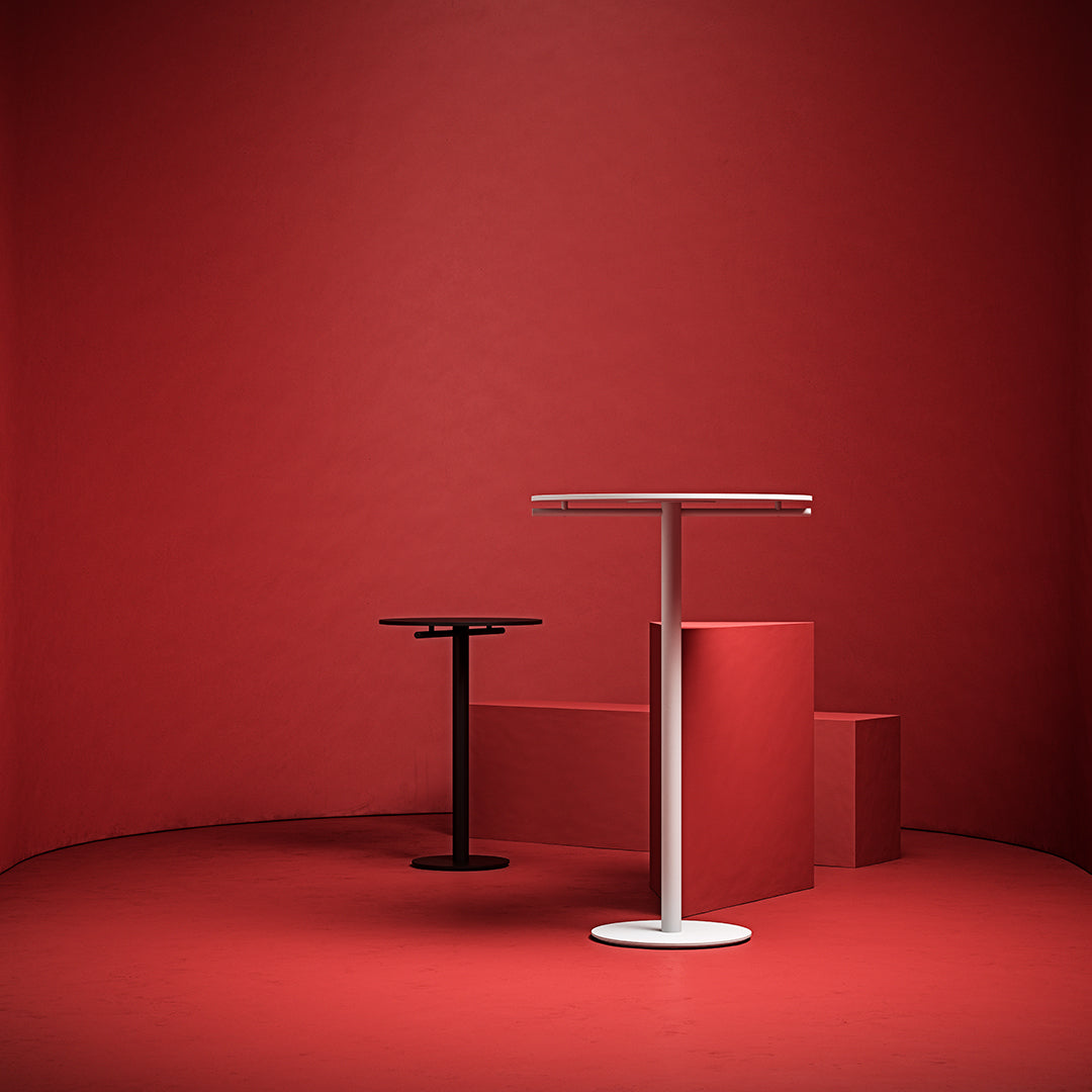 "Modern black and white tables against a bold red backdrop, showcasing sleek lines and minimalist design."