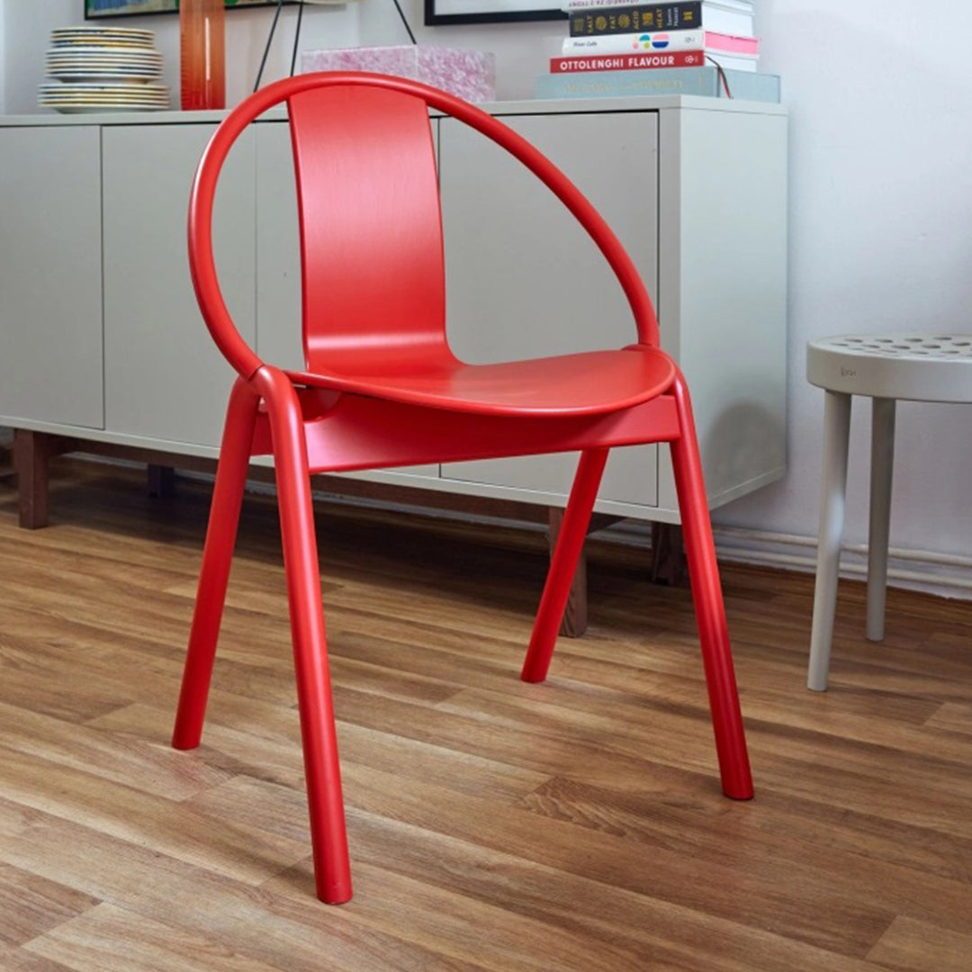 Bright red minimalist chair with a smooth, curved design, perfect for modern decor.