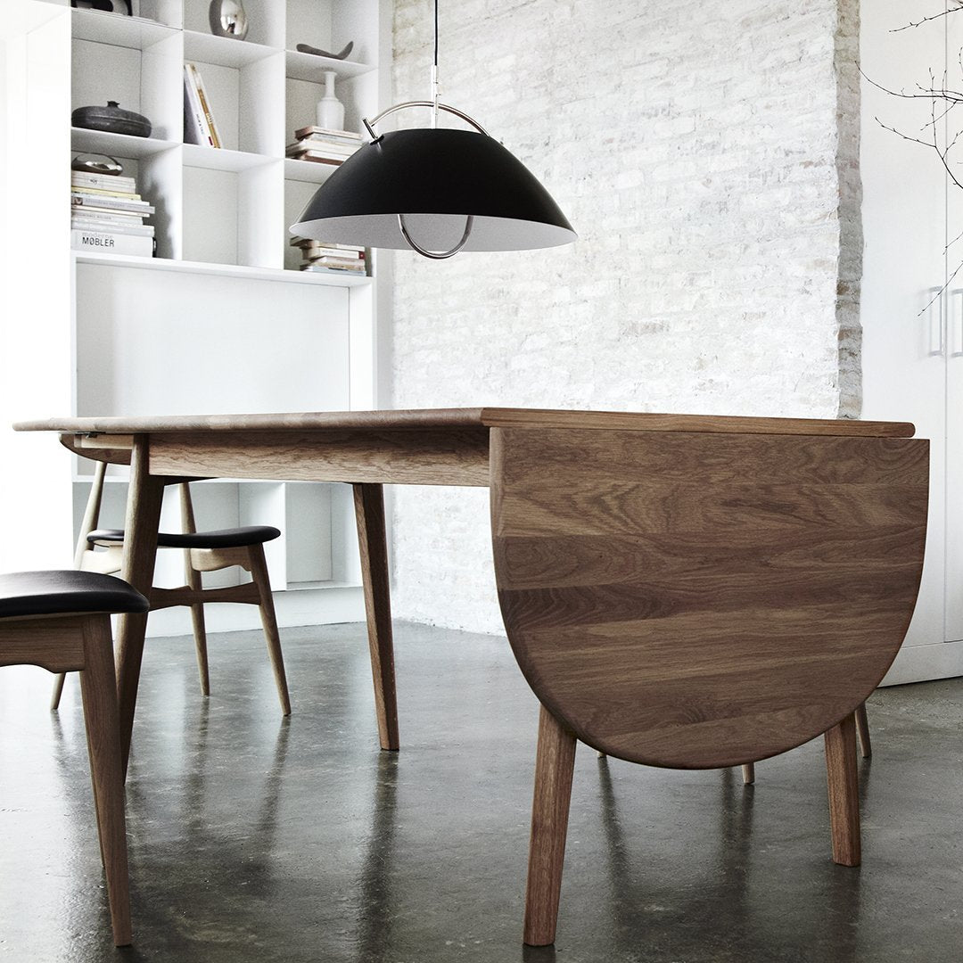 Mid-century modern dining table in warm walnut finish with sleek lines and a natural wood grain pattern.