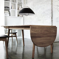 Mid-century modern dining table in warm walnut finish with sleek lines and a natural wood grain pattern.