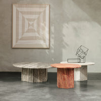 Three decorative coffee tables featuring intricate marble patterns in gray, white, and red, set against a minimalist backdrop.
