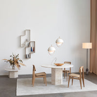 Modern dining room featuring beige and white color palette, textured stone table, and natural wood chairs. Stylish minimalism.