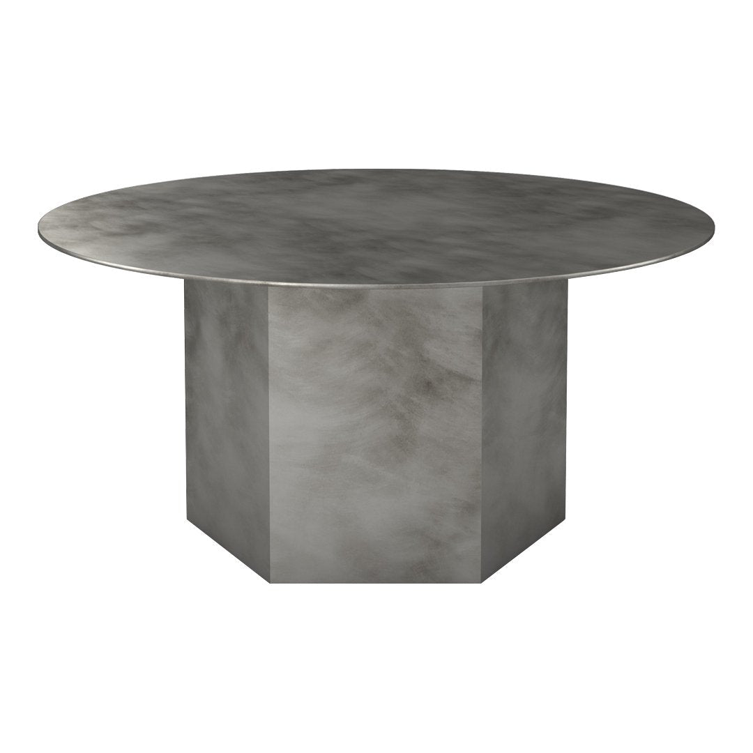 Round gray metal dining table with a smooth, brushed surface and geometric block base design.