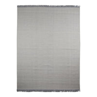 Gray woven rug with a subtle gradient pattern and fringed edges, perfect for modern decor.