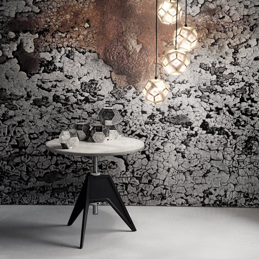 Modern white and black table with geometric patterns, set against a textured gray and rust backdrop.