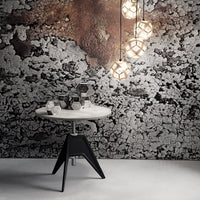Modern white and black table with geometric patterns, set against a textured gray and rust backdrop.