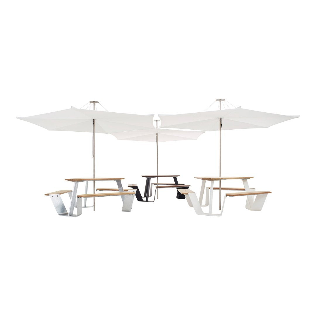 White umbrellas and wooden picnic tables with black and white accents create a modern outdoor dining setup.