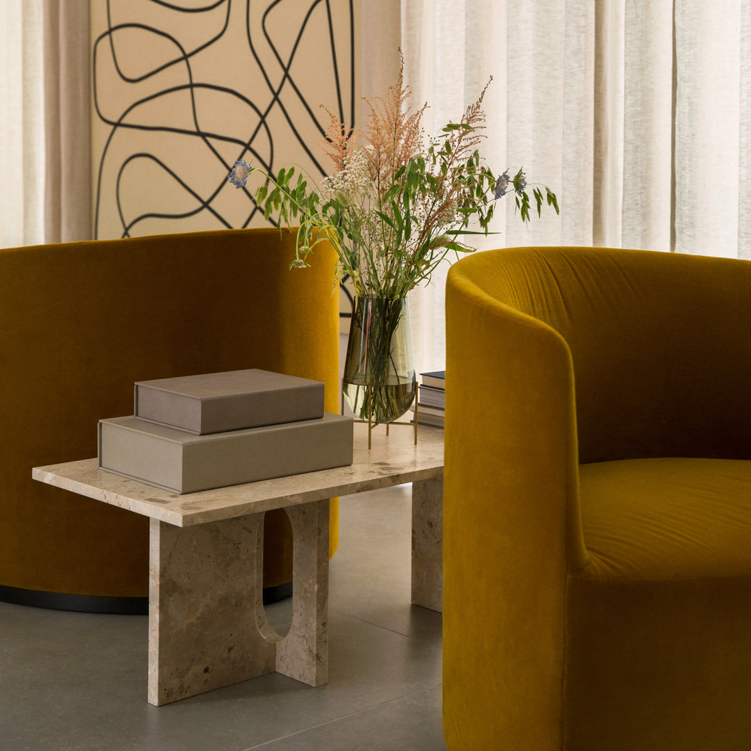 "Vintage mustard yellow chairs with a sleek cream marble table and soft neutral decor accents."