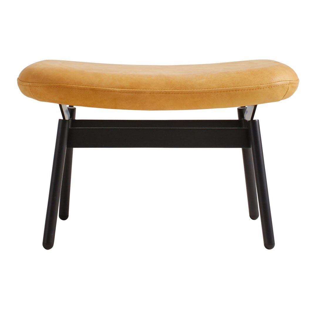 Modern curved bench with a soft mustard yellow cushion and sleek black wooden legs.