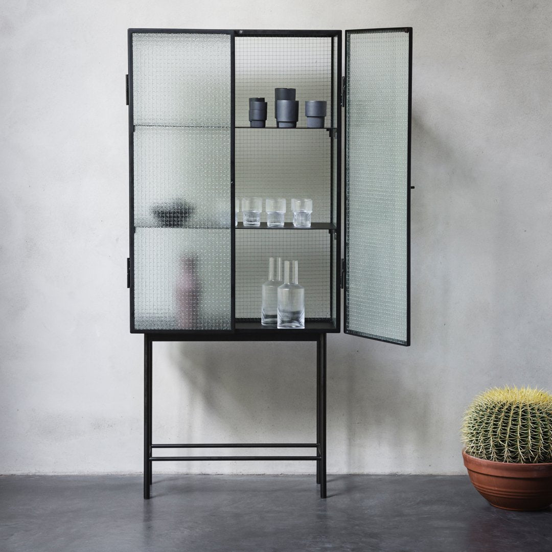 Black metal cabinet with frosted glass panels, showcasing a minimalist design and earthy tones. Perfect for modern decor.