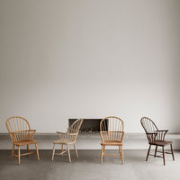 Set of four stylish wooden chairs in natural, light beige, medium brown, and dark brown finishes.