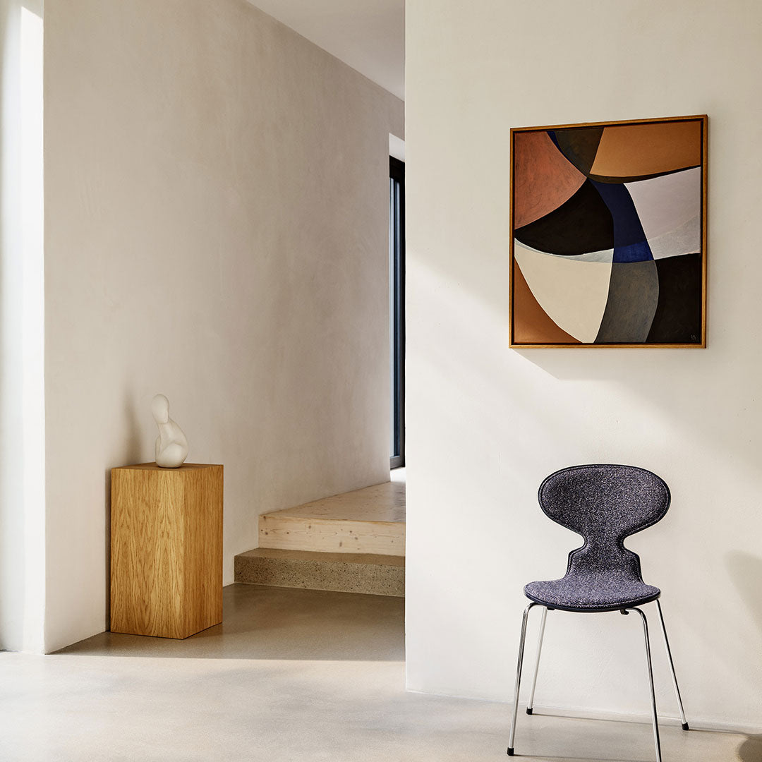 "Stylish chair in deep purple, paired with a modern geometric wall art featuring earthy tones and bold shapes."