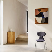 "Stylish chair in deep purple, paired with a modern geometric wall art featuring earthy tones and bold shapes."