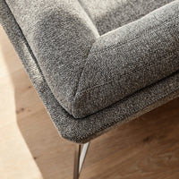 Gray textured upholstery with subtle patterns, complemented by sleek metal legs on a light wooden floor.