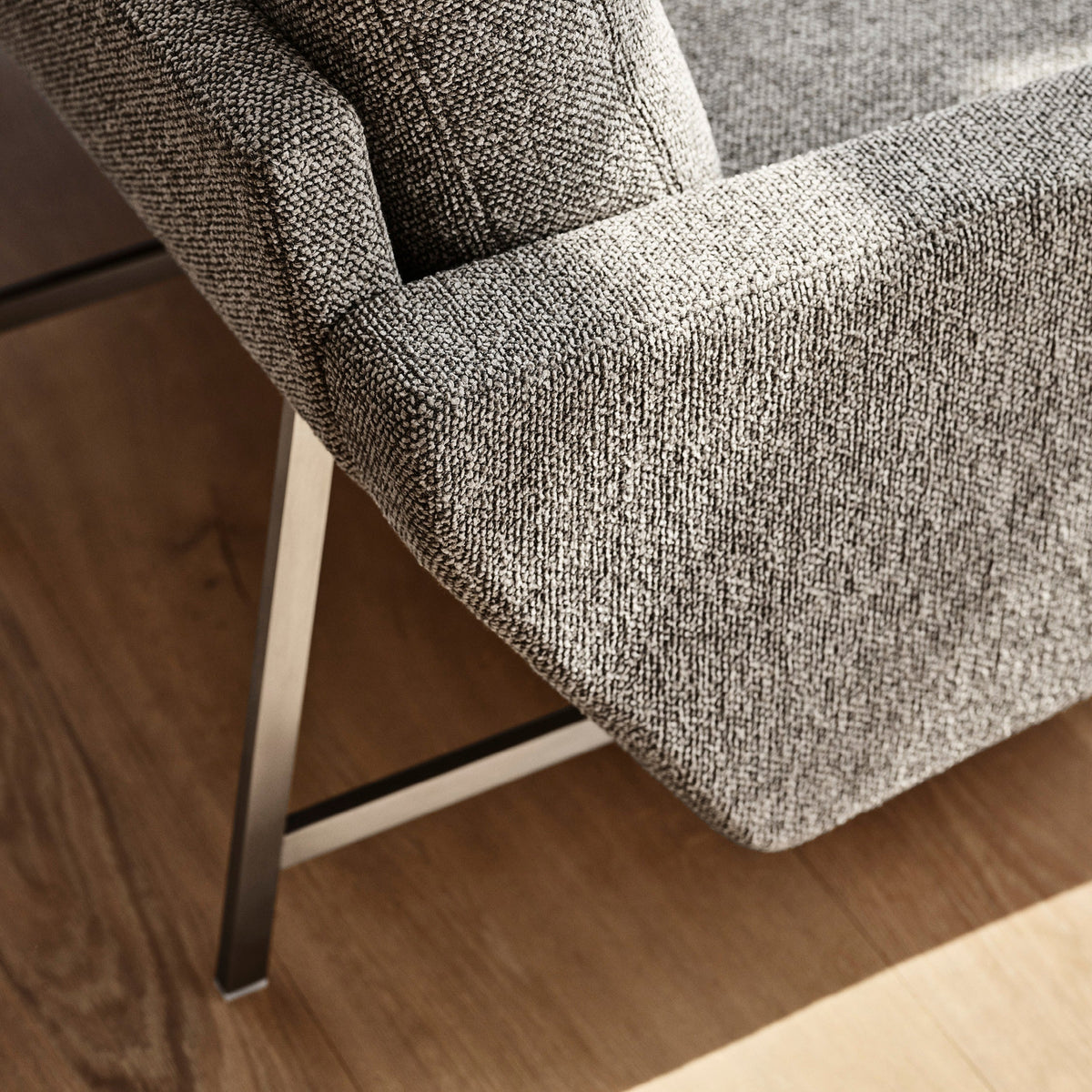 Gray textured upholstery with a subtle woven pattern and sleek silver metal legs. Perfect for modern interiors.