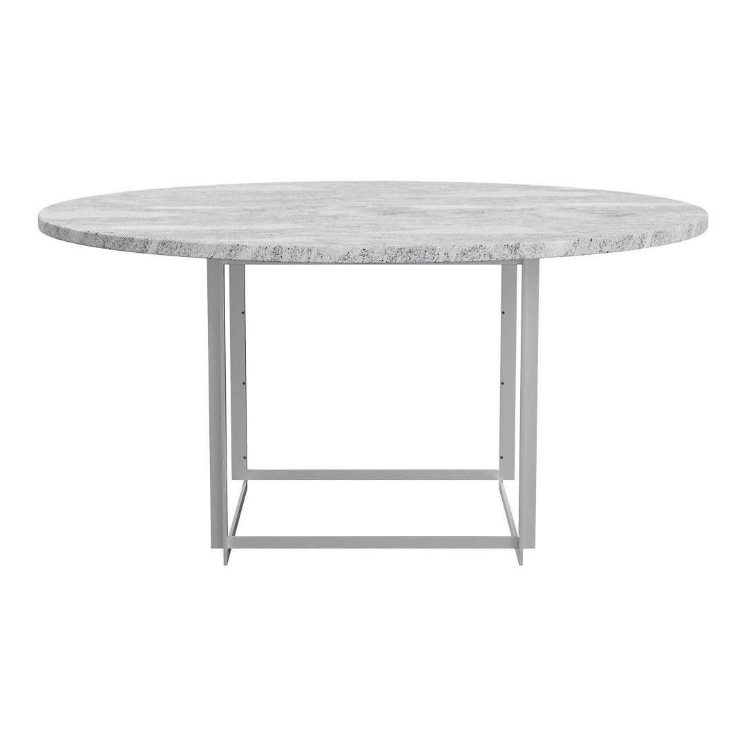Round gray concrete dining table with a textured surface and sleek silver metal legs. Modern and stylish design.