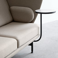 Beige upholstered sofa with a modern design, featuring a sleek black metal side table.