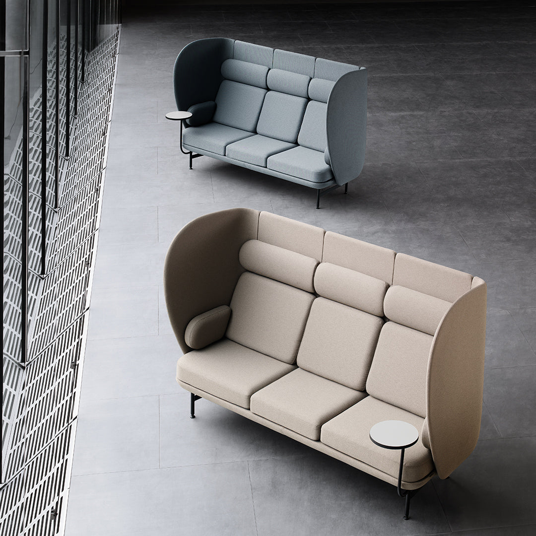 Two modern sofas in light beige and soft blue with sleek, curved lines and metallic accents on a textured gray floor.