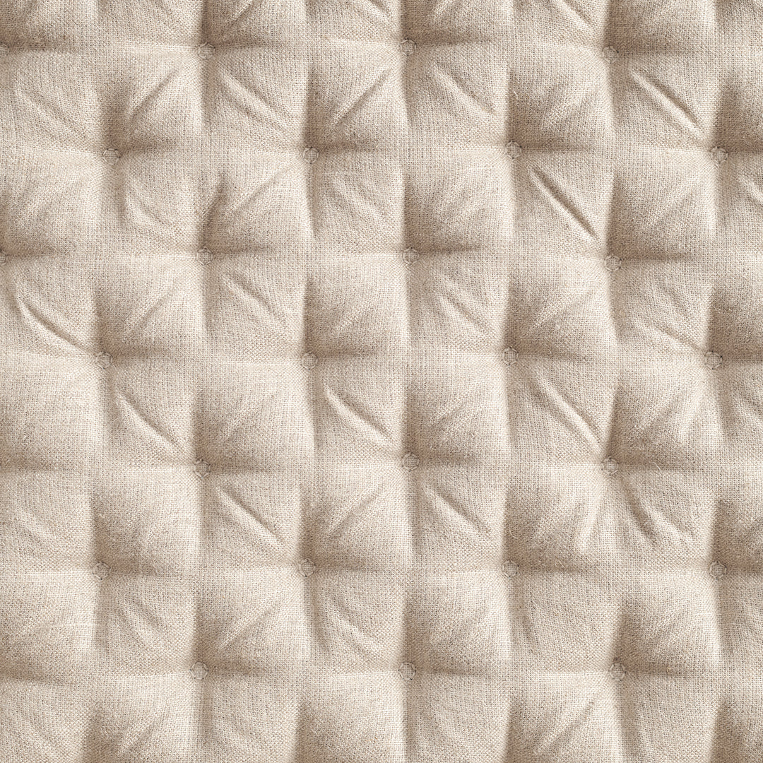 Textured beige fabric with a quilted pattern of small squares, adding depth and sophistication to any design.