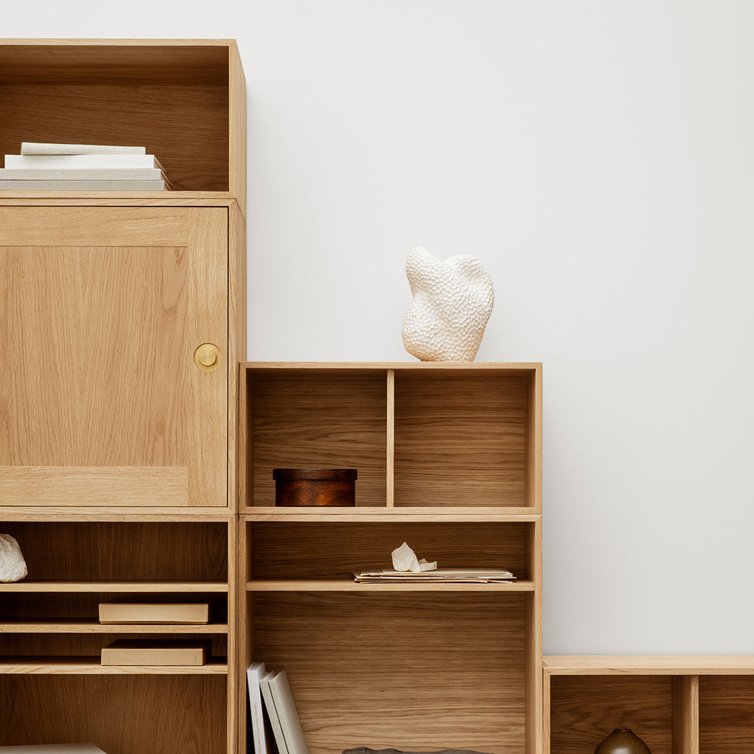 Light wood shelving unit featuring smooth surfaces and natural grain patterns, accented by minimalist decor.