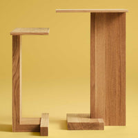 Two modern wooden side tables with a natural wood finish against a bright yellow background. Stylish geometric design.